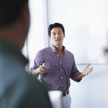 An associate giving a presentation using a whiteboard