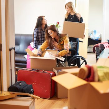 A group of three female university students move into their shared flat , and start to unpack boxes. One of the students is a wheelchair user and is chatting to her new friends as they unpack their boxes in a communal lounge .